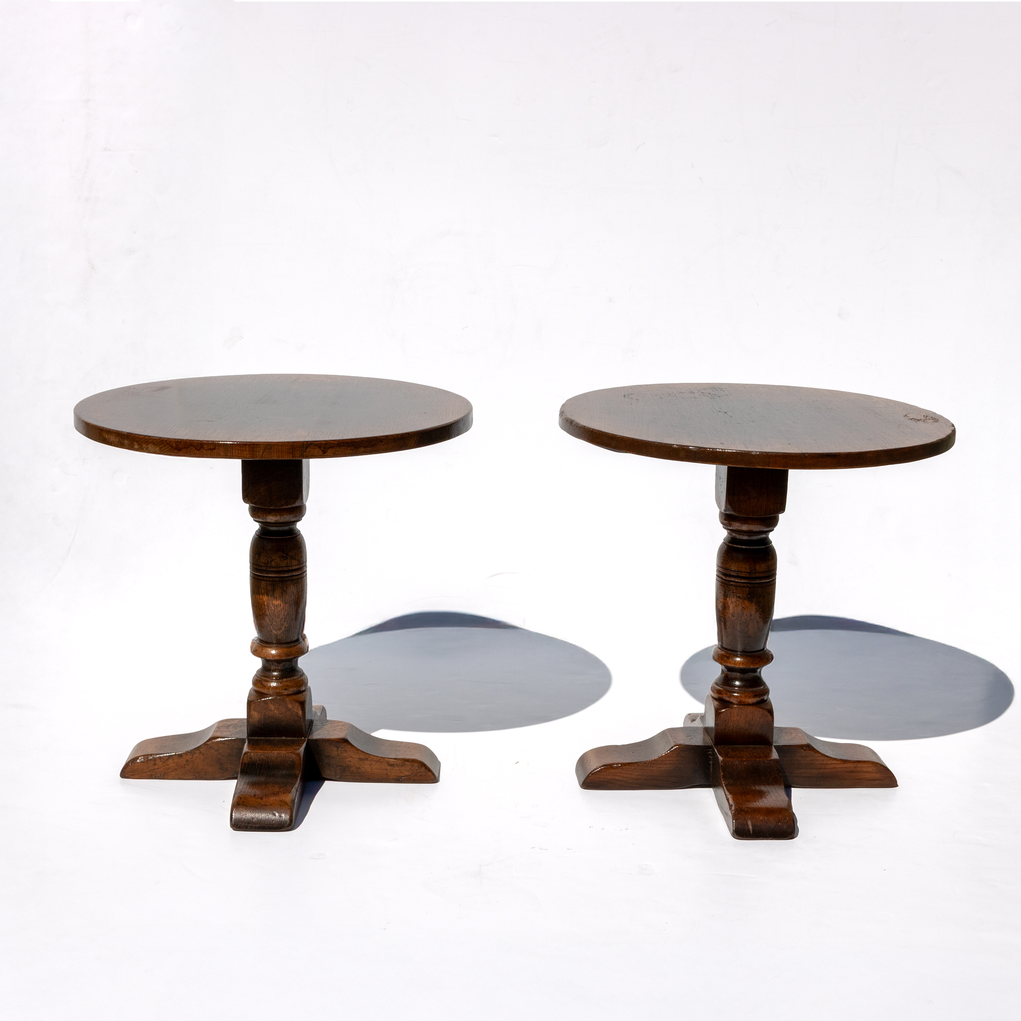 Pair of English oak cocktail tables with circular tops and splayed feet