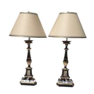 Pair of 19th-century Italian black and silver-gilt candlestick lamps on white background.