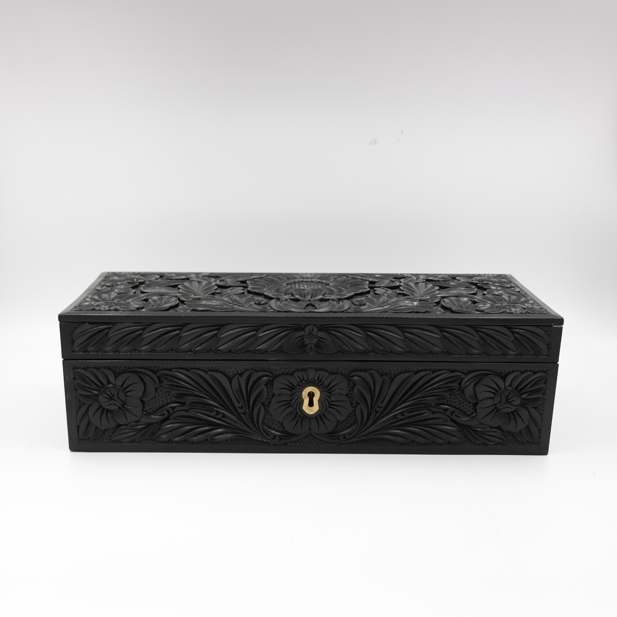 Anglo-Indian carved ebony glove box front view with brass escutcheon