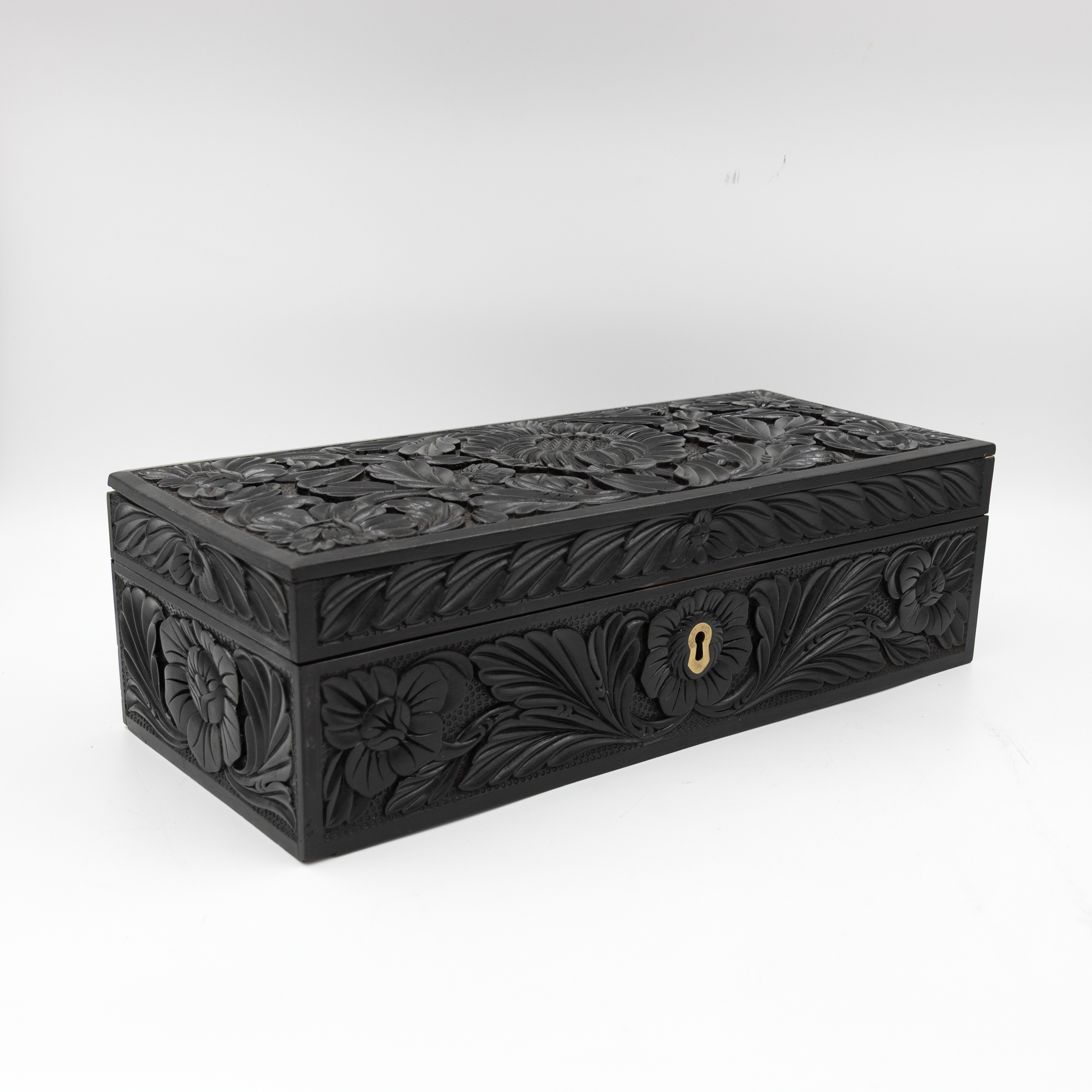 Angled front view of carved ebony box.