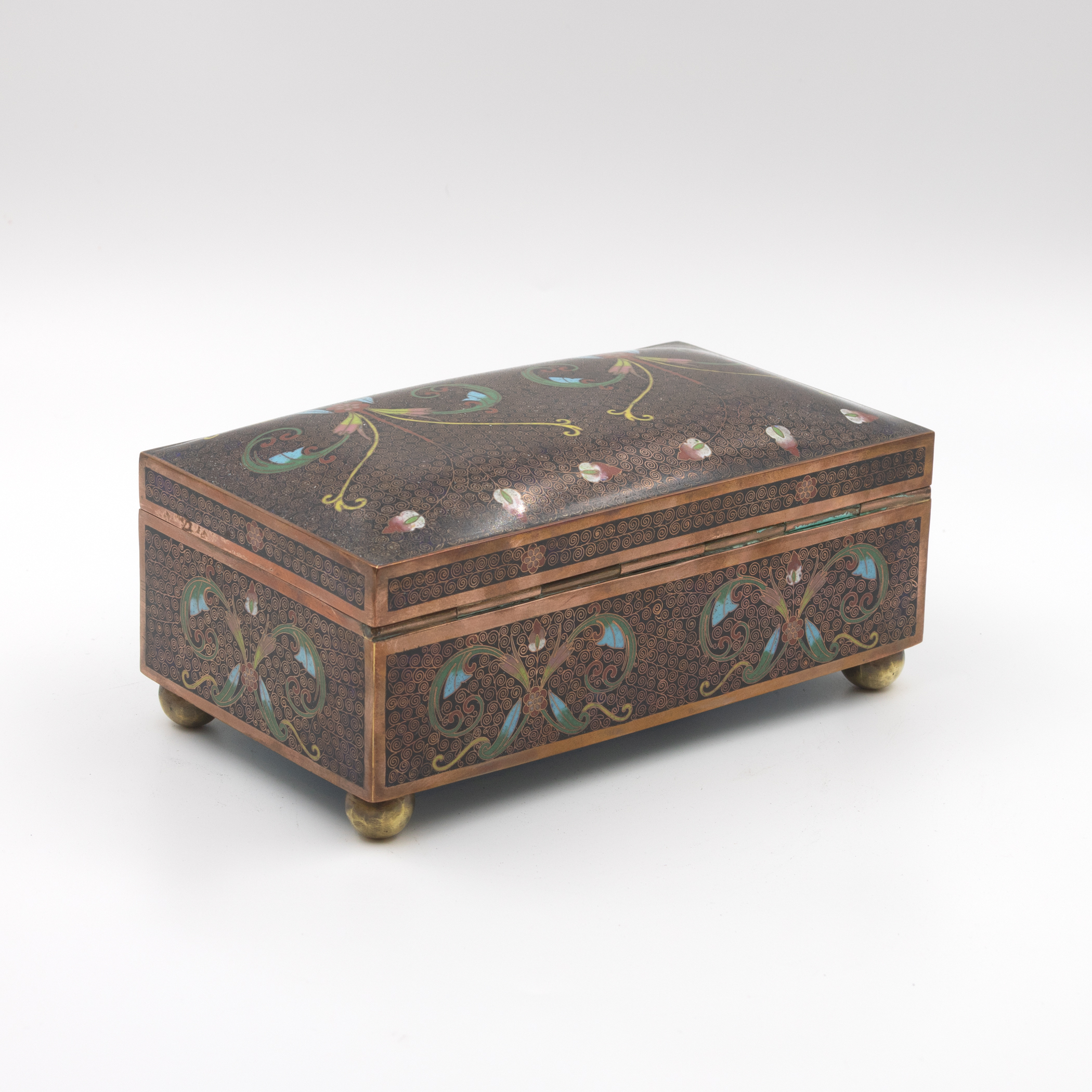 Cloisonné enamel box, rear three-quarter view, domed lid and long back face with foliate scroll decoration, hinge detail, copper banding, ball feet