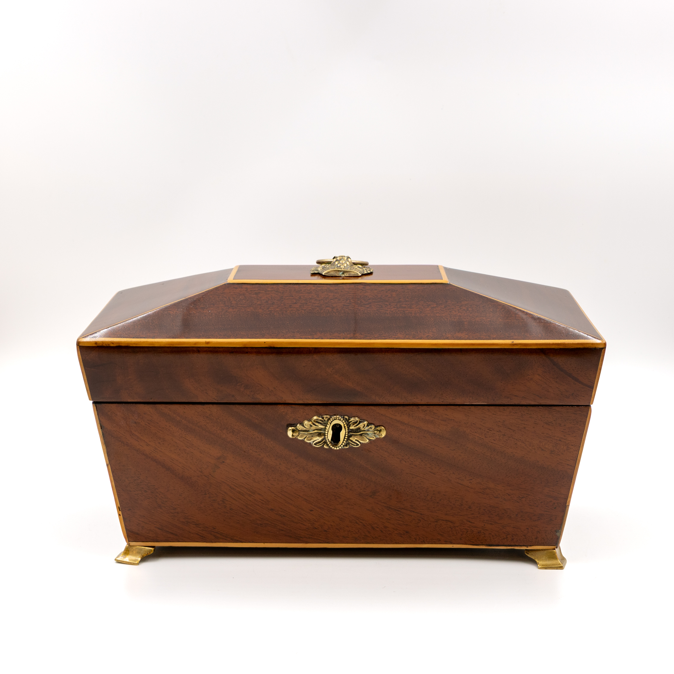 front elevation of regency mahogany box with satinwood edging and brass basket-form ring handle, english circa 1820