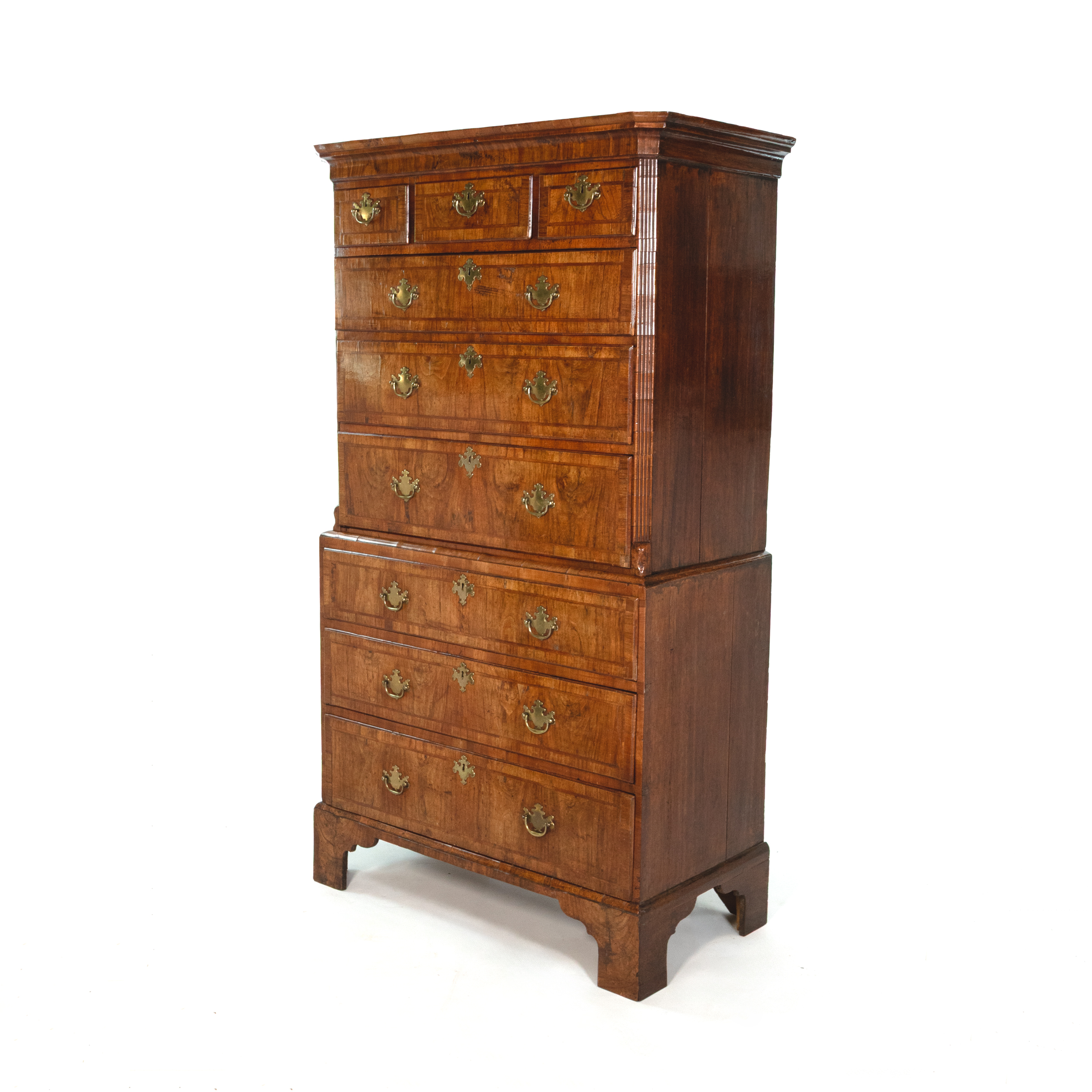 Georgian walnut chest on chest, English, circa 1720, three-quarter view showing reeded corners and bracket feet
