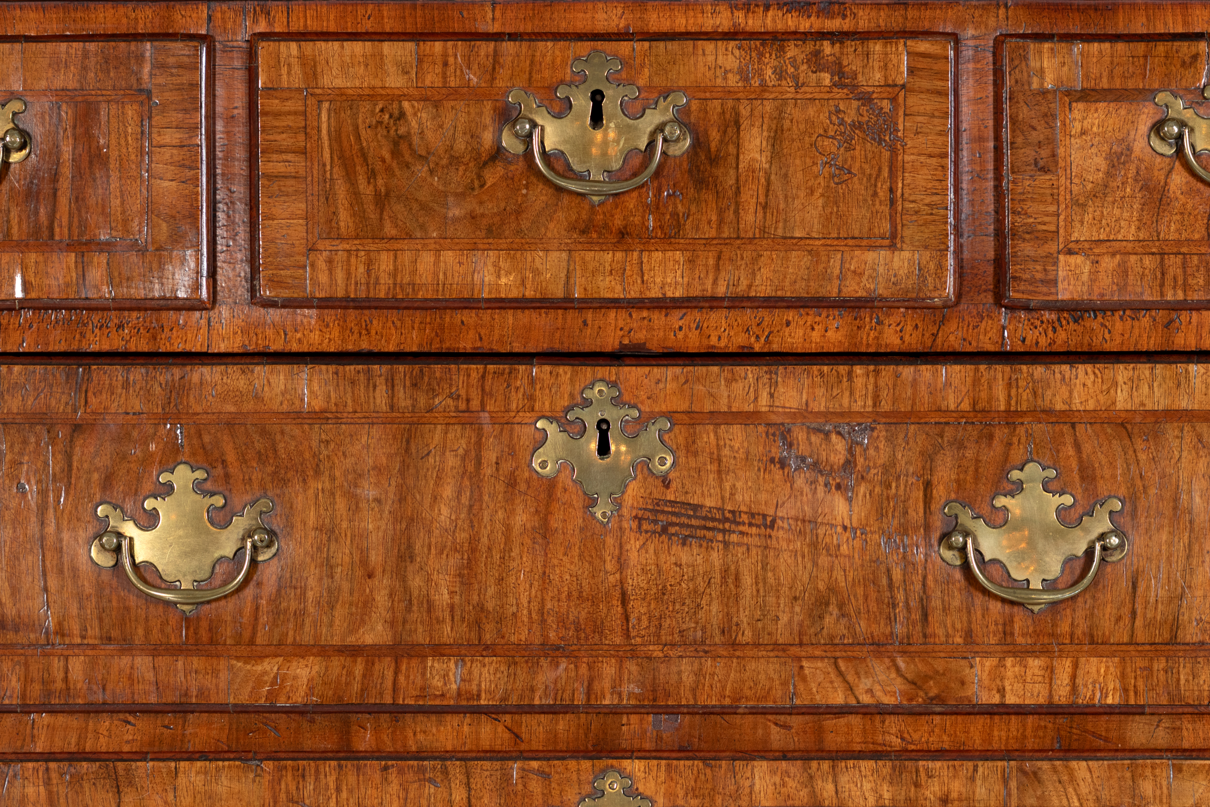 Detail of crossbanded walnut drawer fronts and brass hardware, Georgian chest on chest, circa 1720