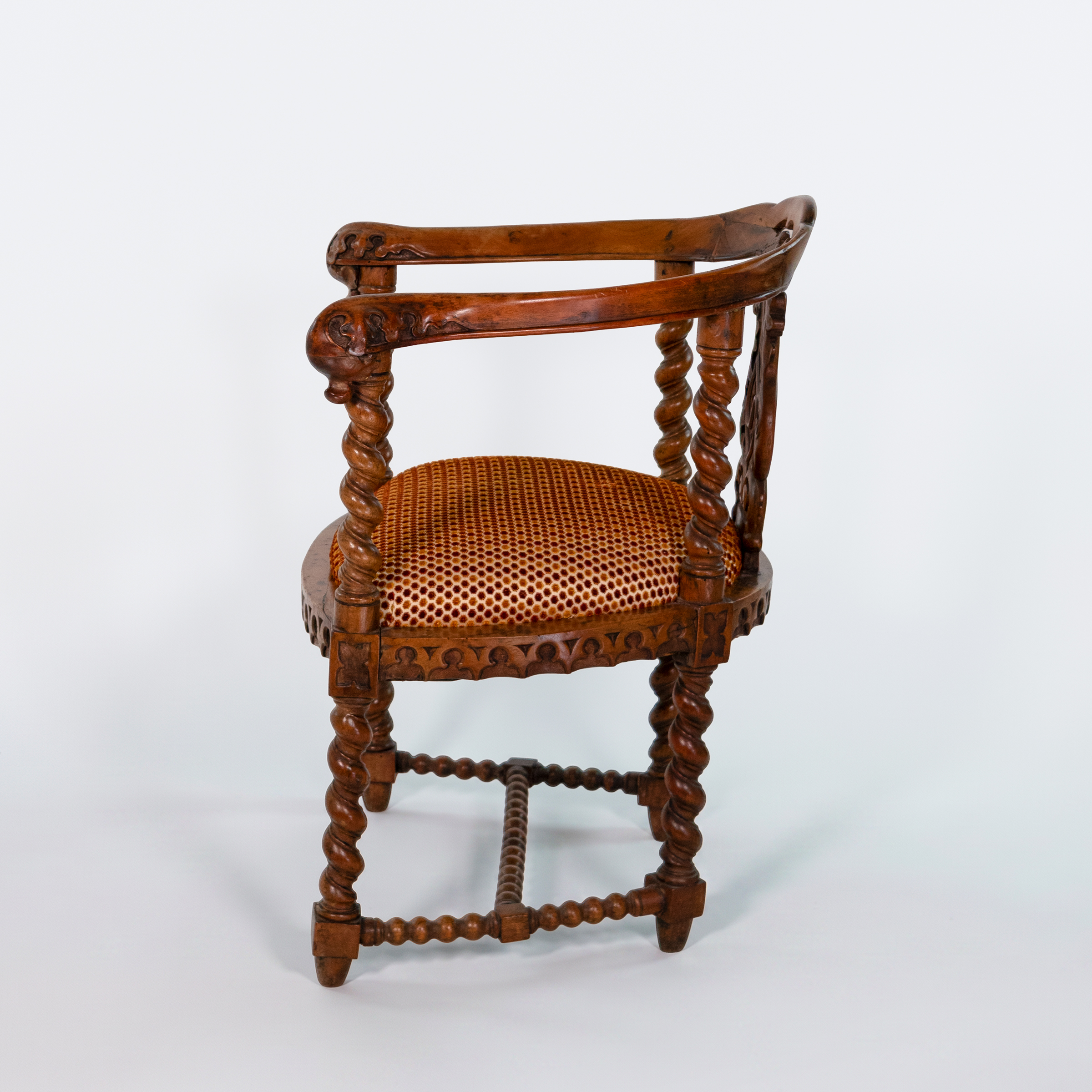 Side view of English Gothic Revival yew tub chair with barley-twist supports and Gothic apron