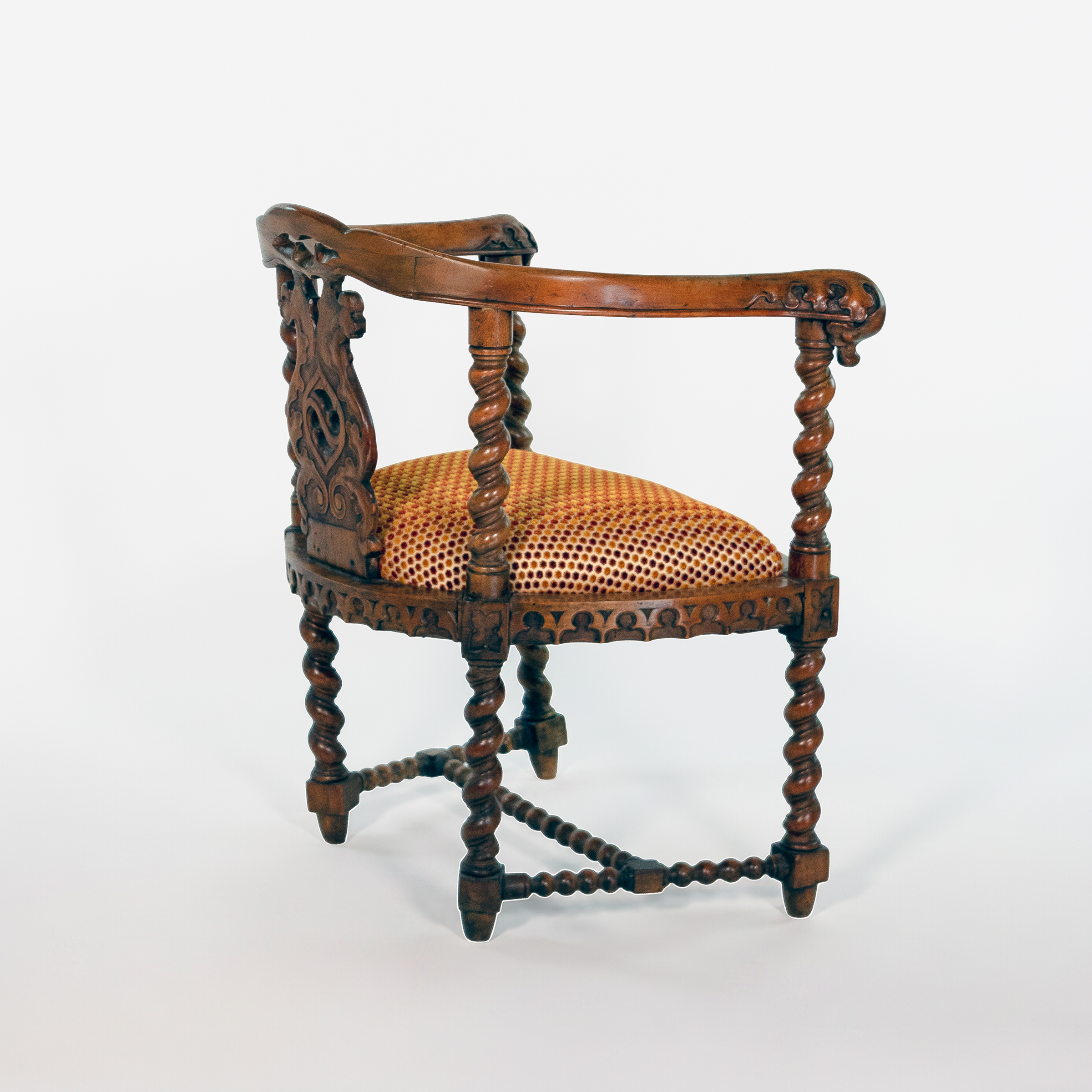 Rear three-quarter view of English Gothic Revival yew tub chair with Gothic carving