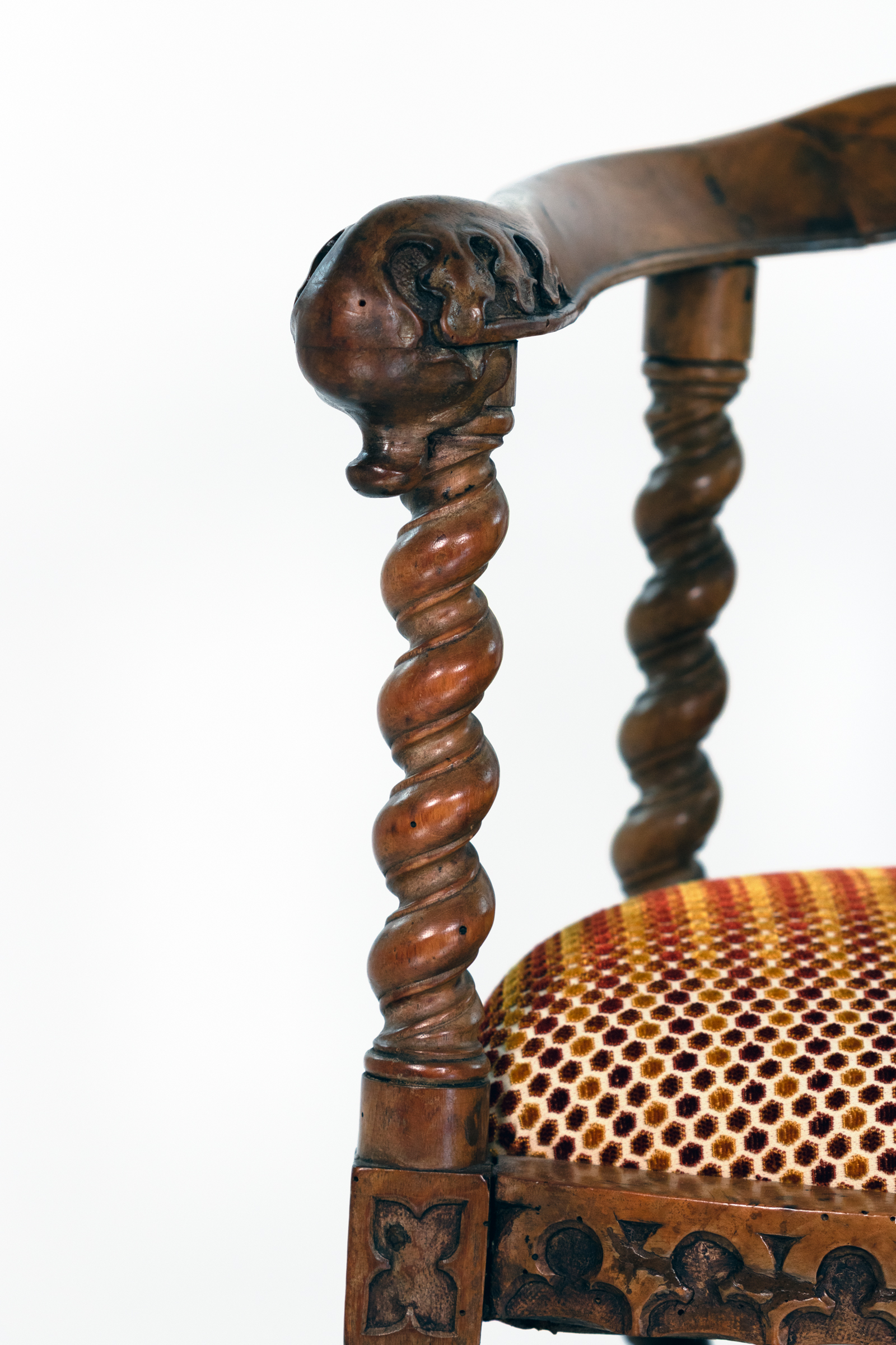 Detail of carved arm terminal and barley-twist support on Gothic Revival yew tub chair