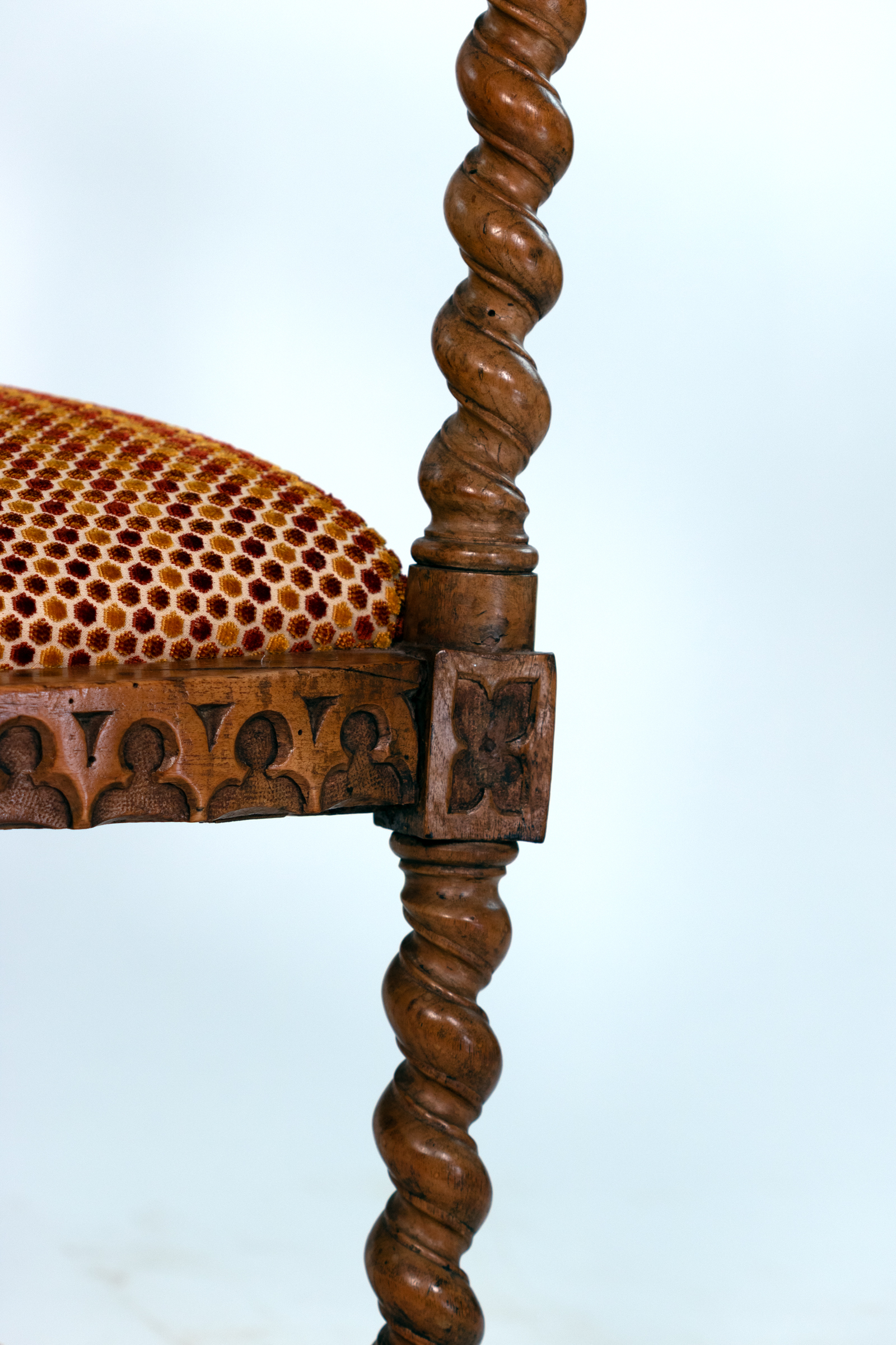 Detail of barley-twist support and upholstered seat on Gothic Revival yew tub chair
