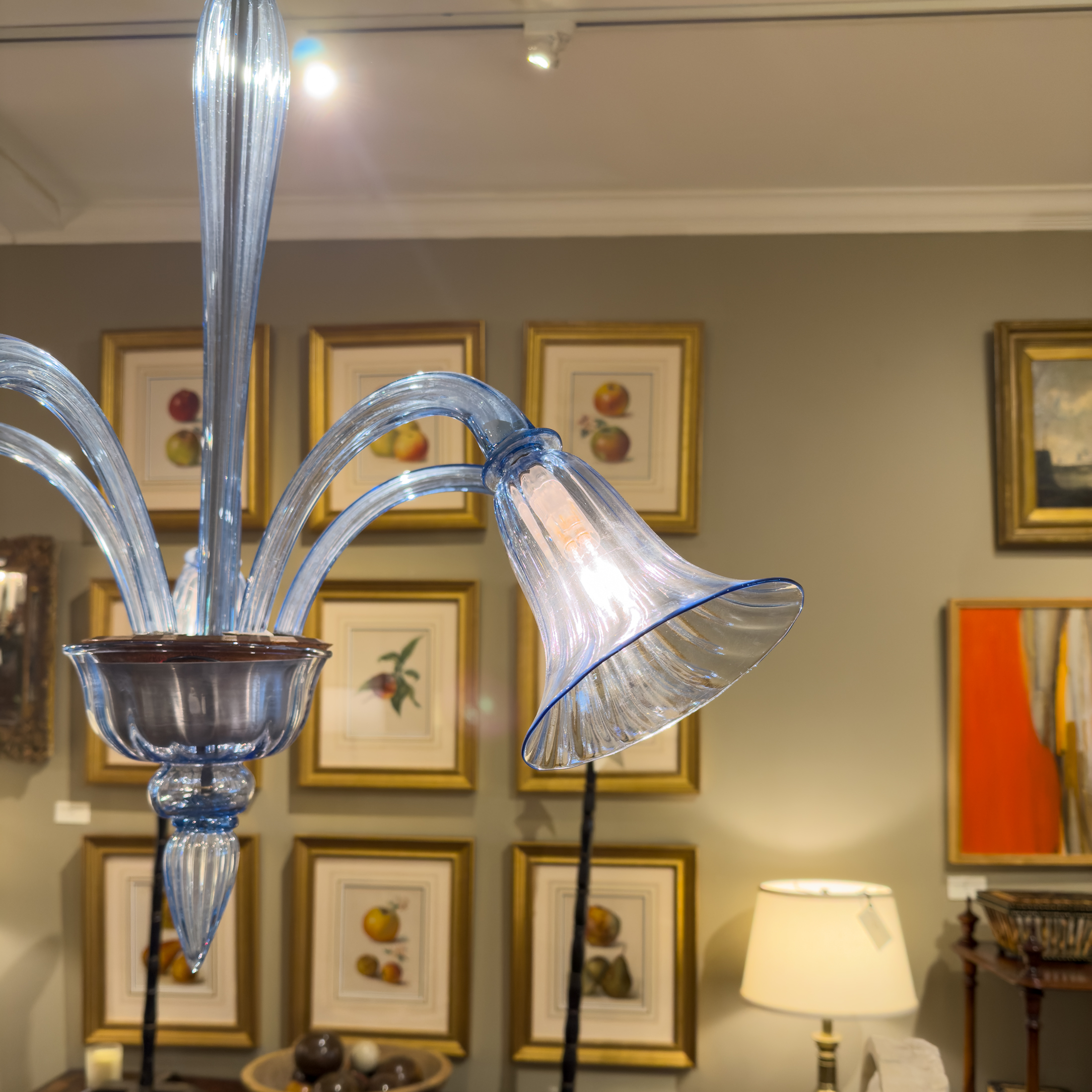 Detail of a pale blue Venetian glass chandelier showing a trumpet shade with blue rim, ribbed bowl and pointed finial