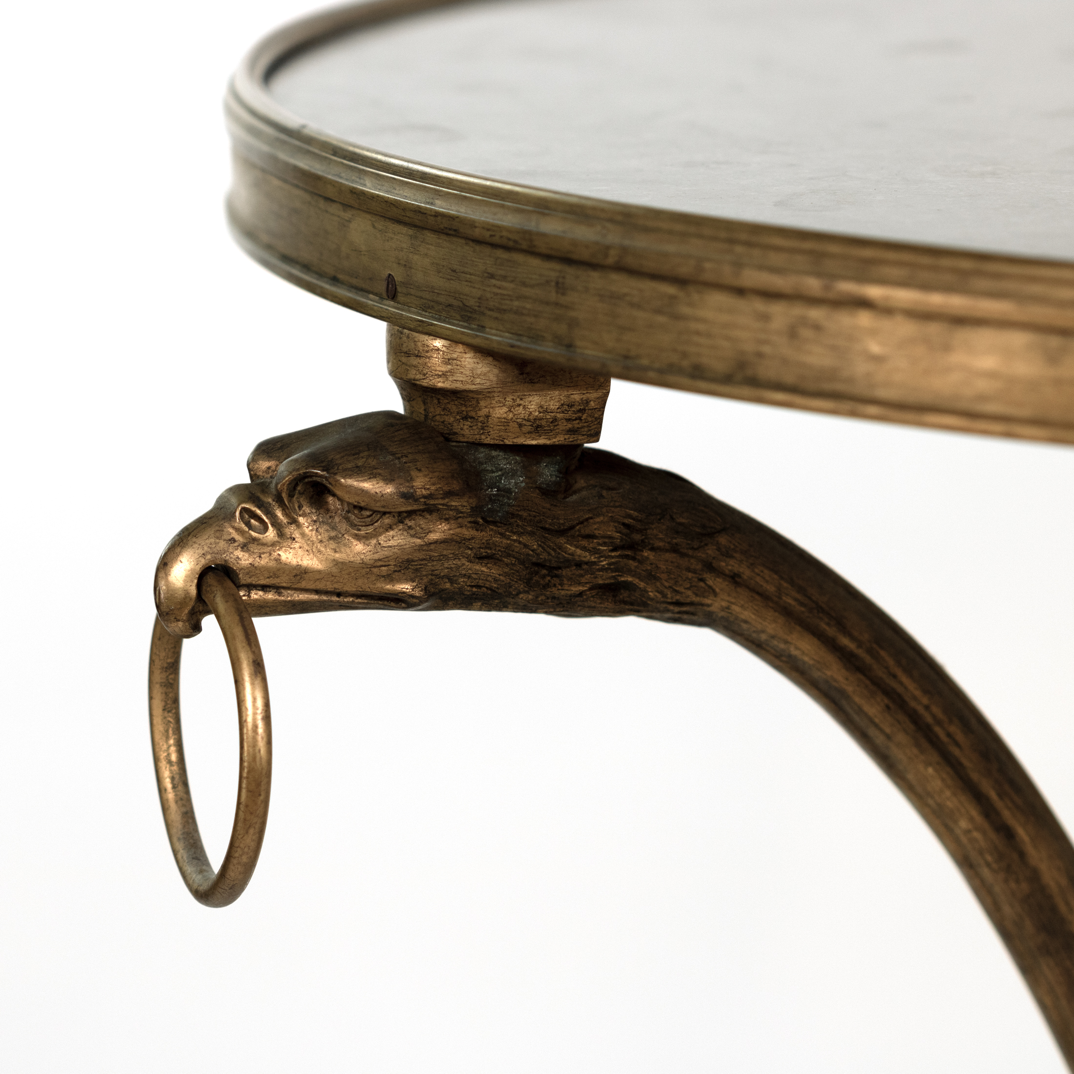 Detail of projecting eagle-head terminal holding a loose ring on a French gilt-bronze gueridon