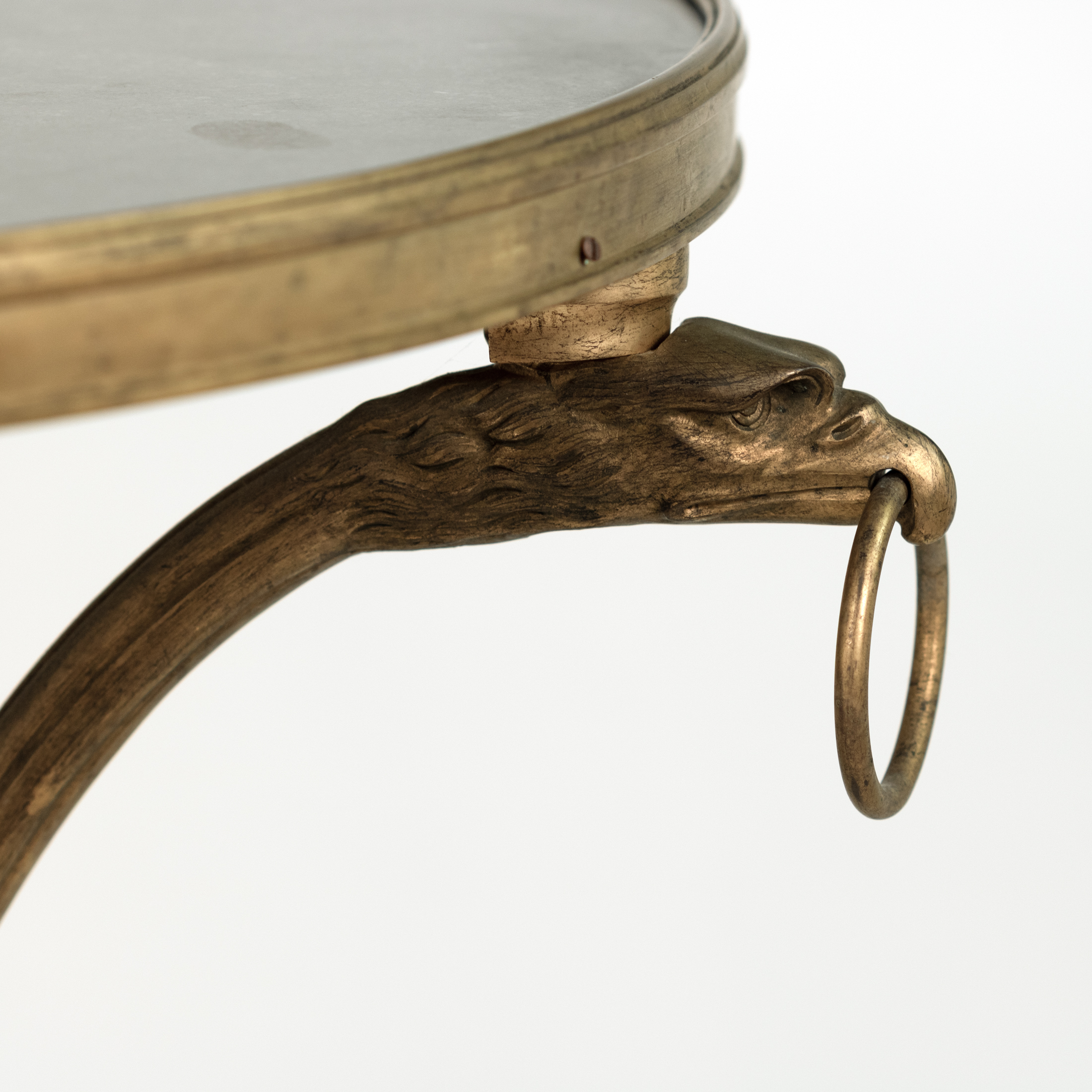 Profile detail of a projecting eagle-head terminal and ring on a French gilt-bronze gueridon, circa 1880