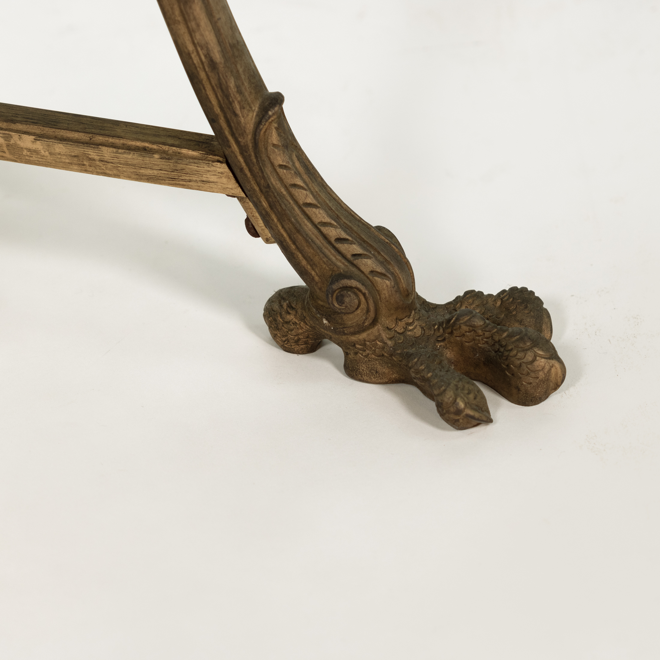 Detail of a large bird-talon foot with foliate and scroll ornament on a French gilt-bronze gueridon