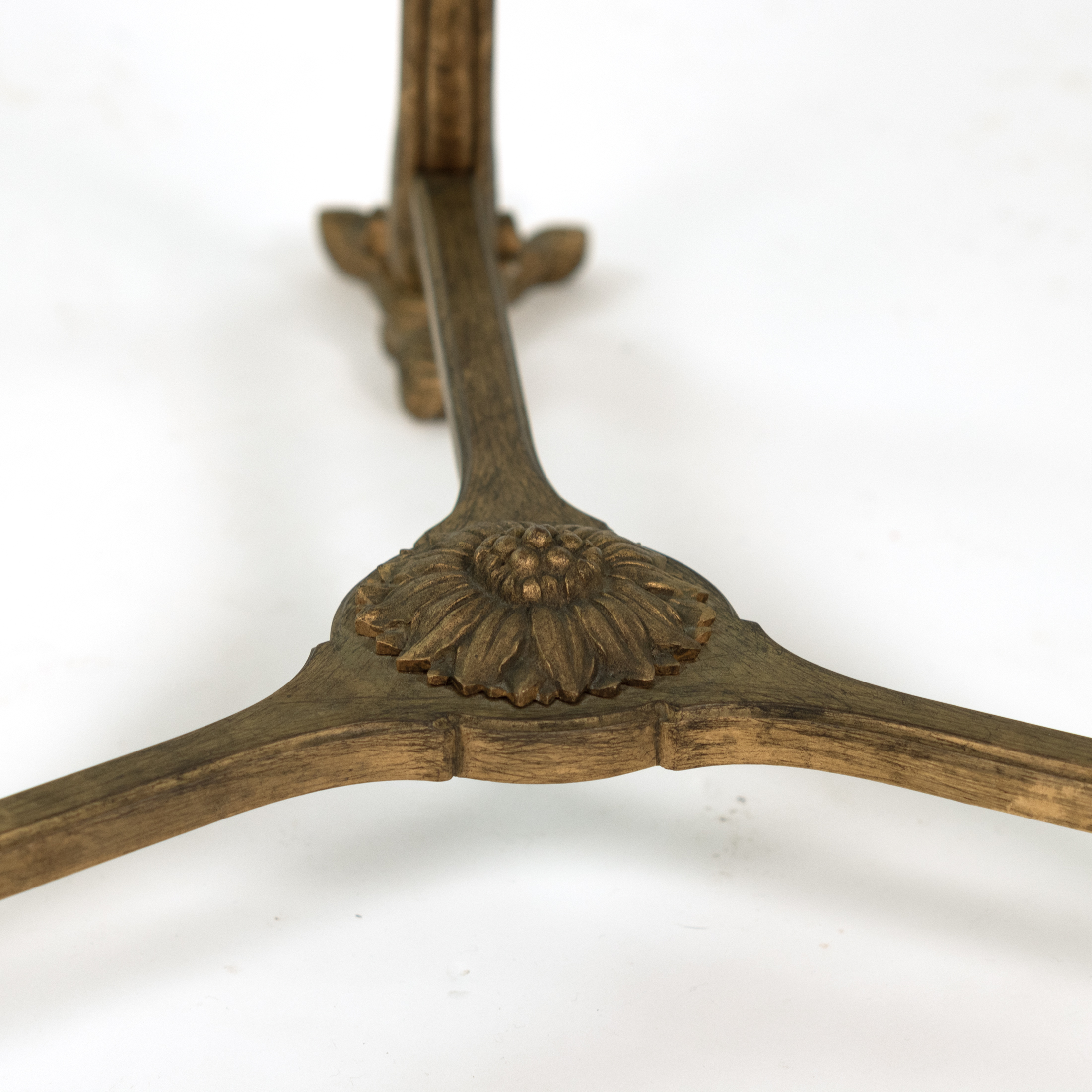 Detail of cast foliate rosette centered on the tripartite stretcher of a French gilt-bronze gueridon