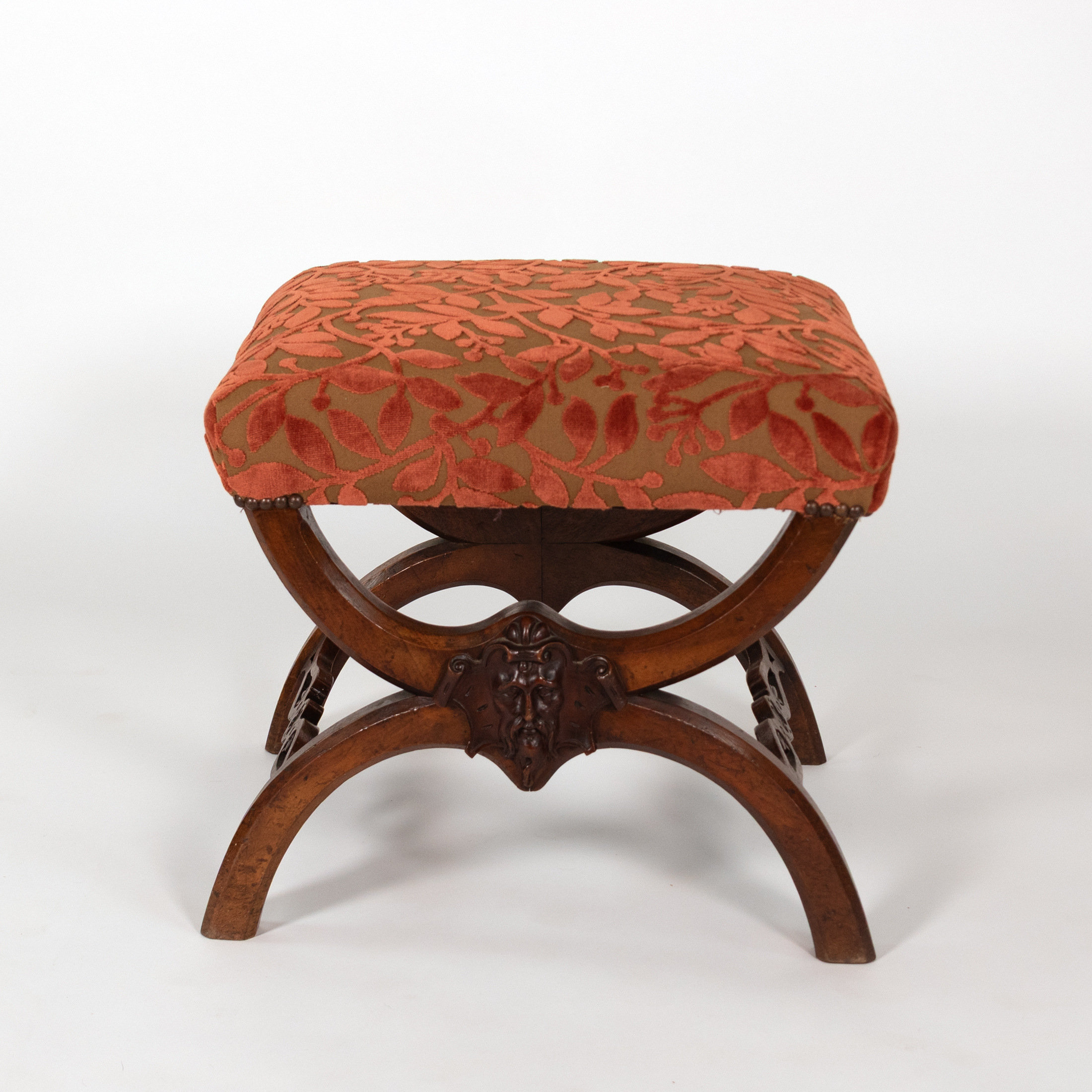 French walnut curule-form stool with coral cut velvet seat and carved bearded mask, circa 1830
