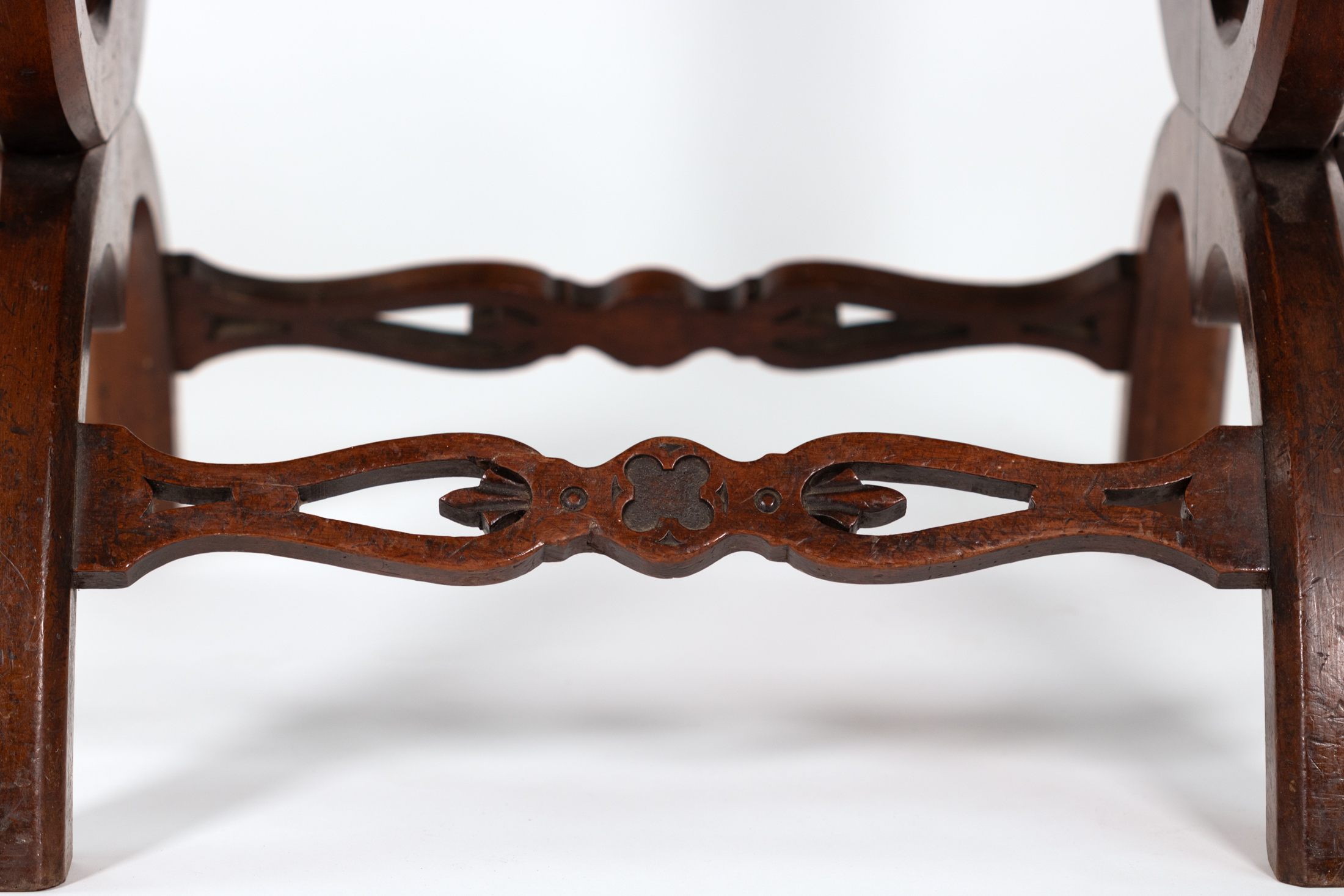 Pierced and shaped stretchers of a French walnut curule-form stool, circa 1830