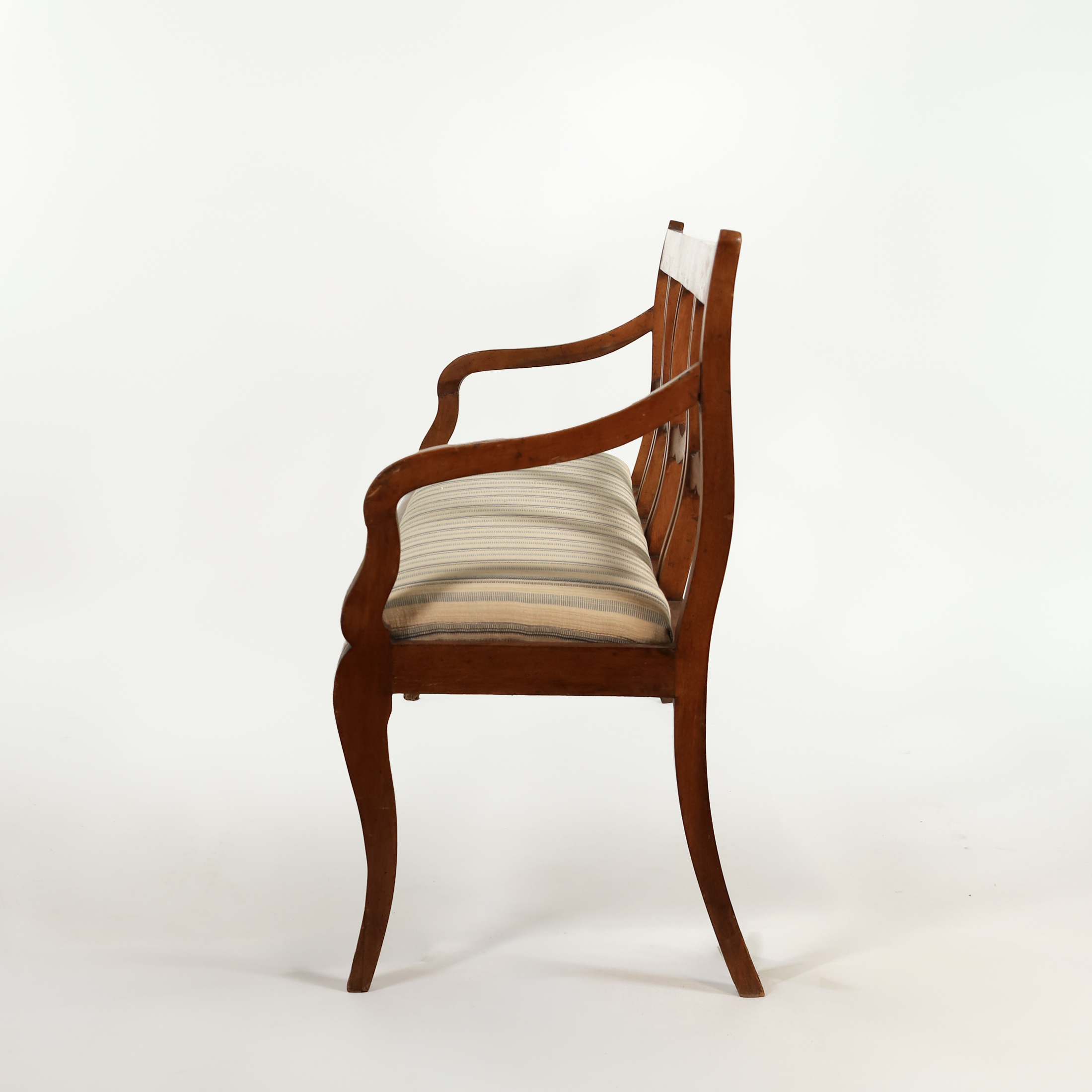 Side profile of Italian walnut bench circa 1880 showing curved arm, upholstered seat and sabre legs