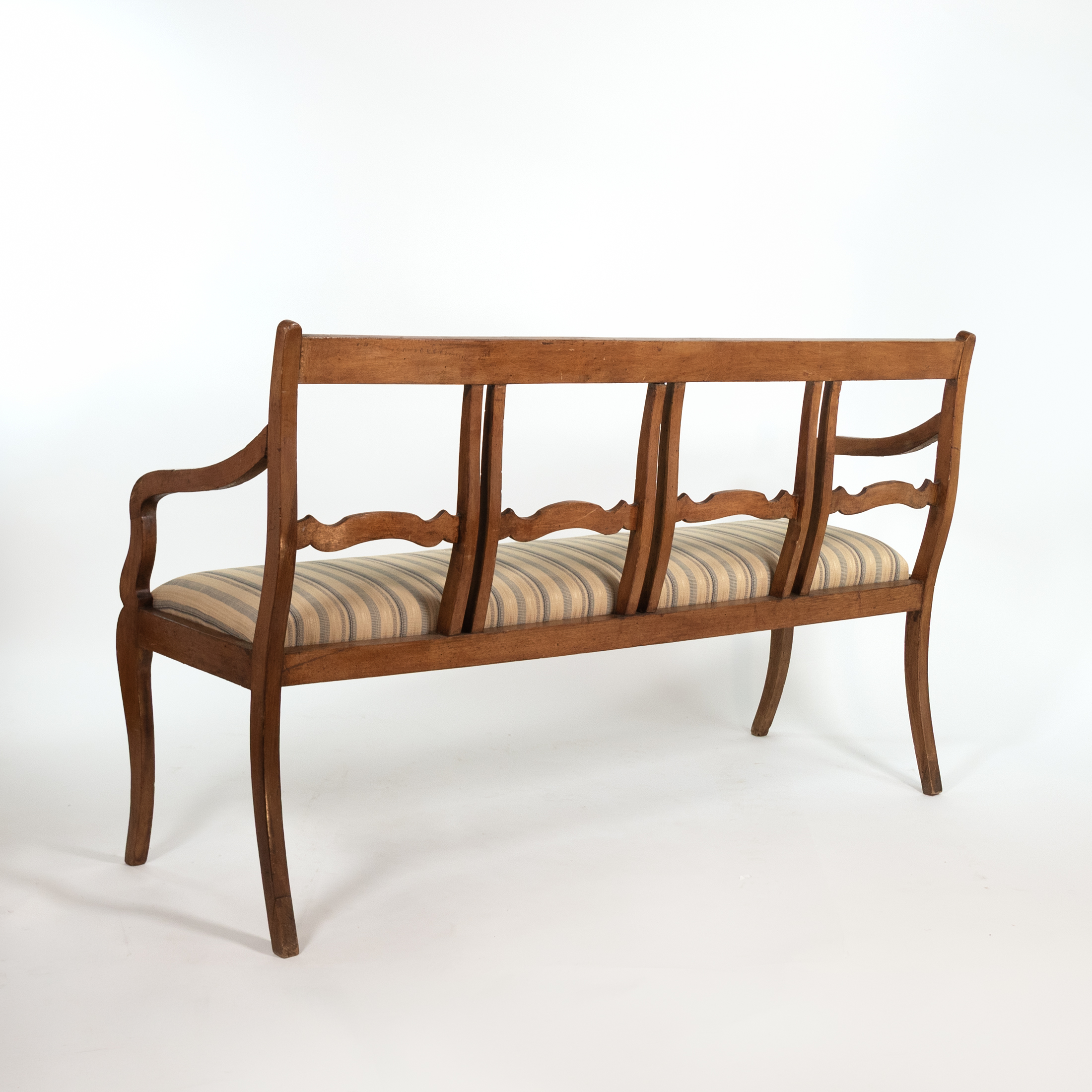 Rear three-quarter view of Italian walnut bench circa 1880 with open back and scalloped rails