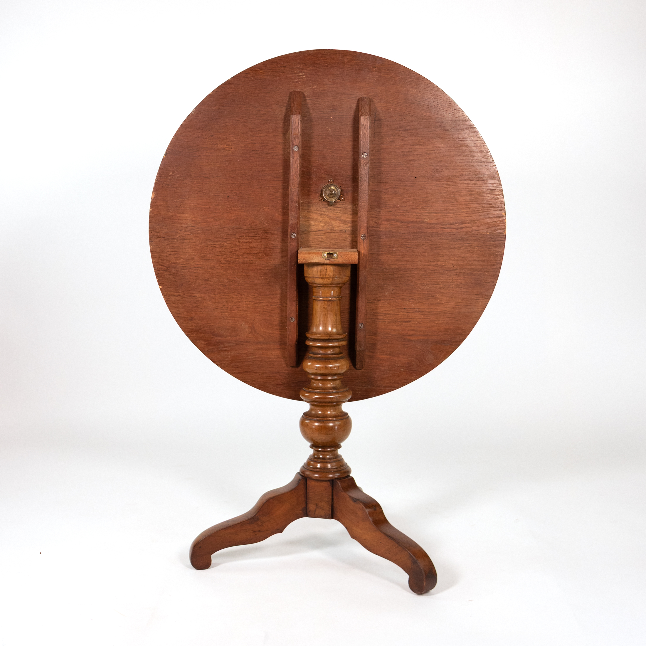 Reverse of an English Victorian tilt-top side table, circa 1870, showing underside battens, tilting block and brass catch.