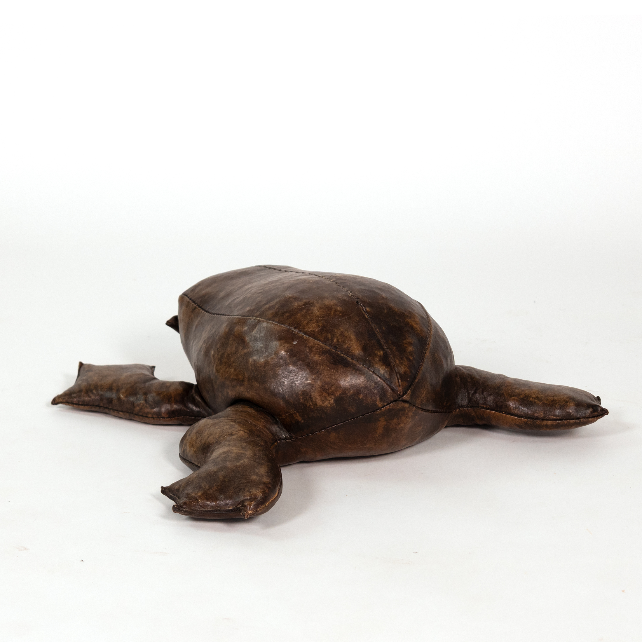 Three-quarter view of leather frog footstool in the manner of Dimitri Omersa showing stitched back panels