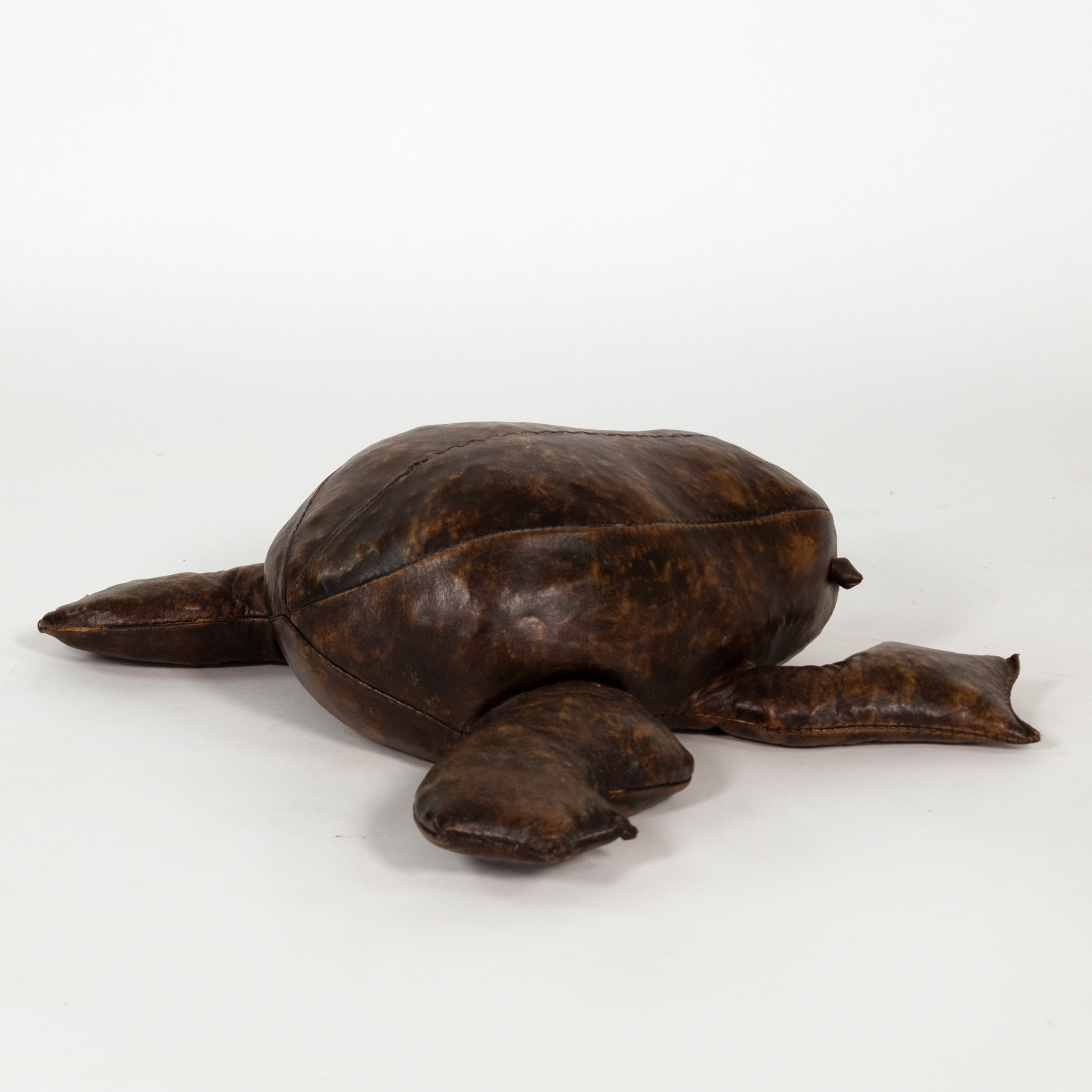 Opposite side view of brown leather frog footstool in the manner of Dimitri Omersa