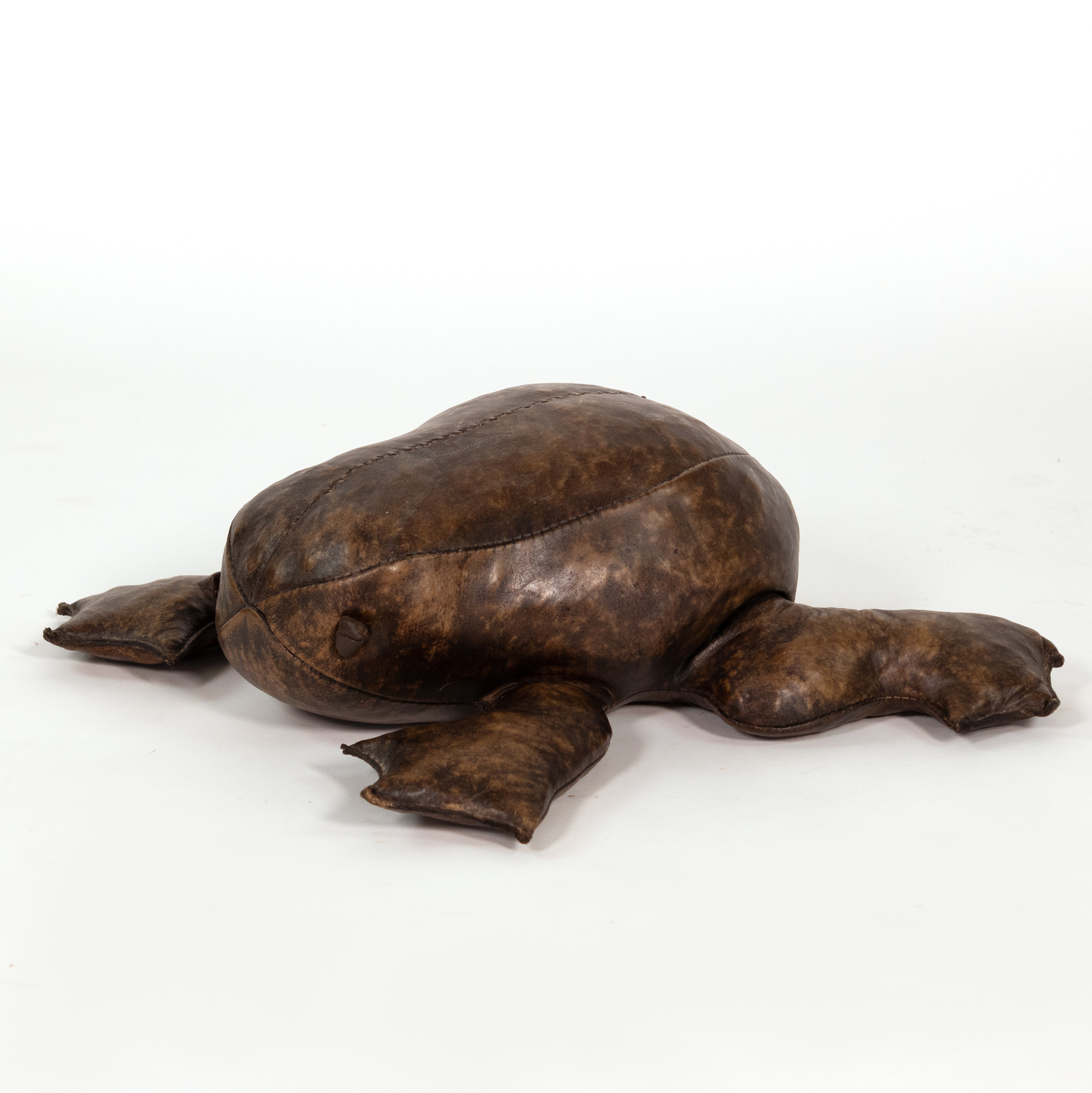 Three-quarter side view of leather frog footstool in the manner of Dimitri Omersa with mottled brown surface