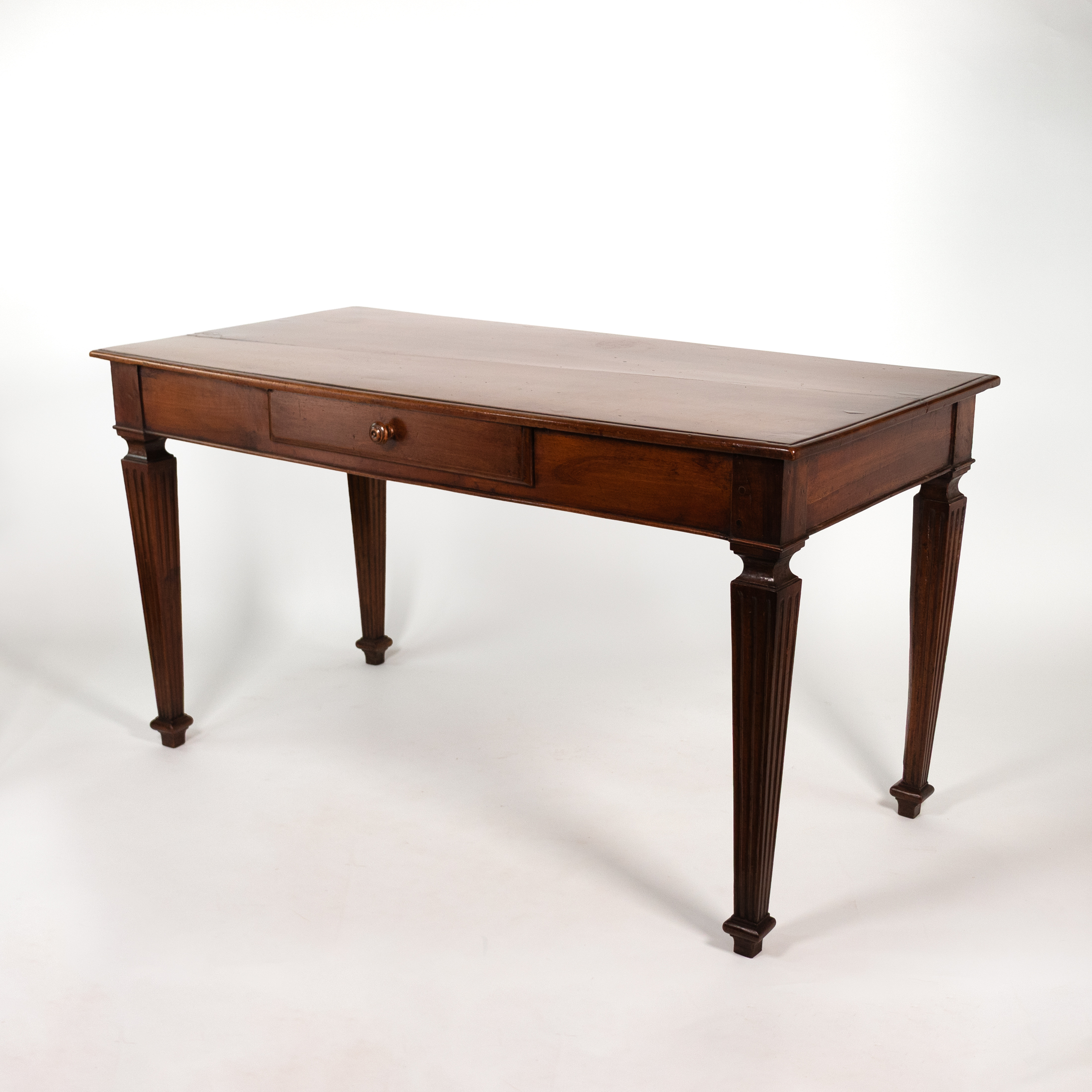 Italian Neoclassical walnut writing table, circa 1800, three-quarter front view.