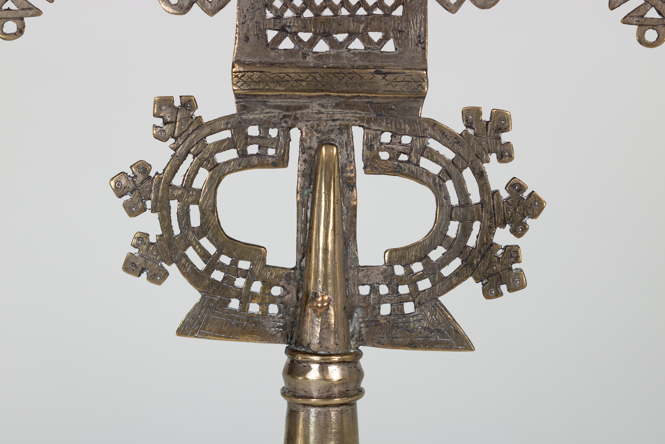 Detail of Ethiopian processional cross openwork loops and brass tang above the staff socket