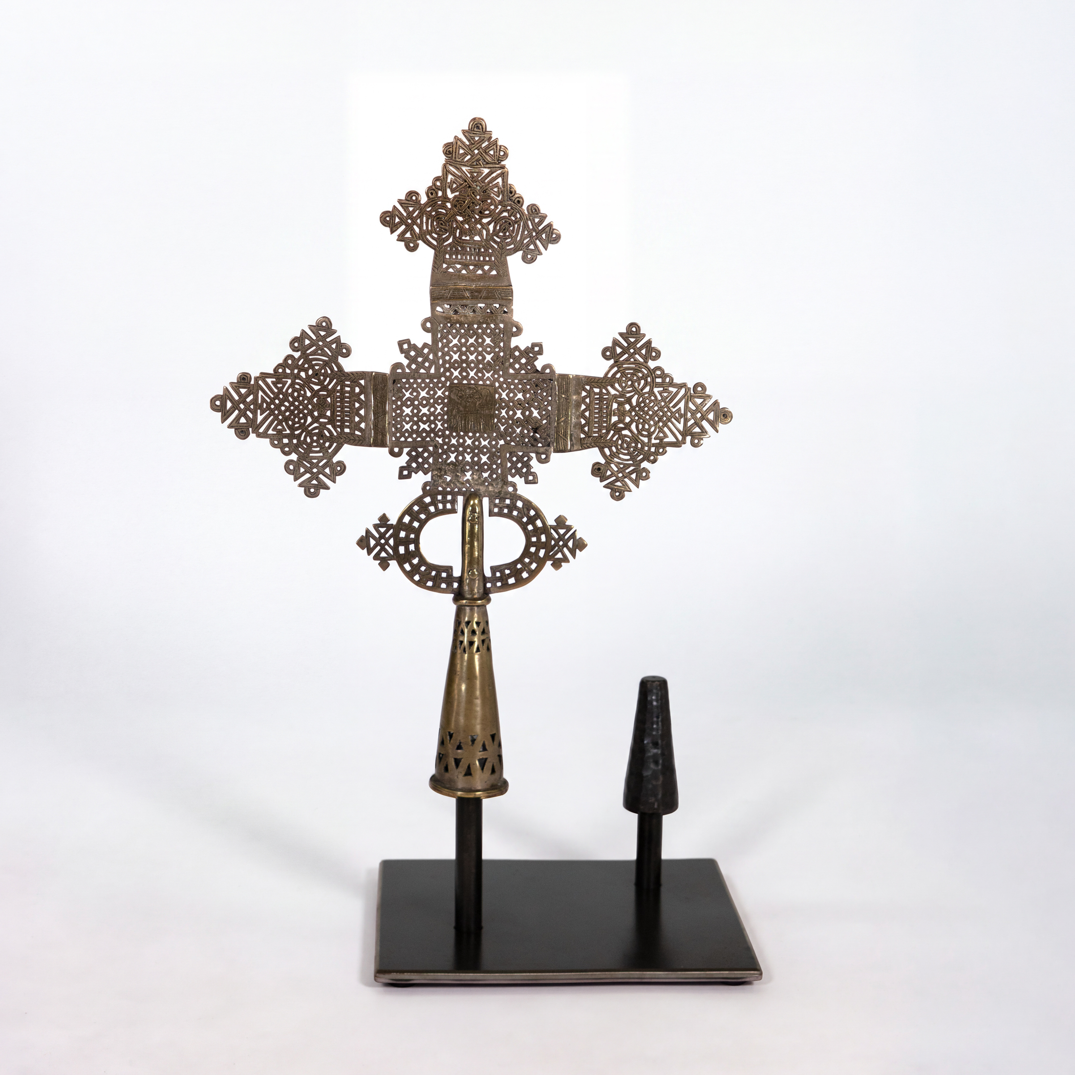 Smaller Ethiopian brass processional cross mounted singly on steel stand, reverse view