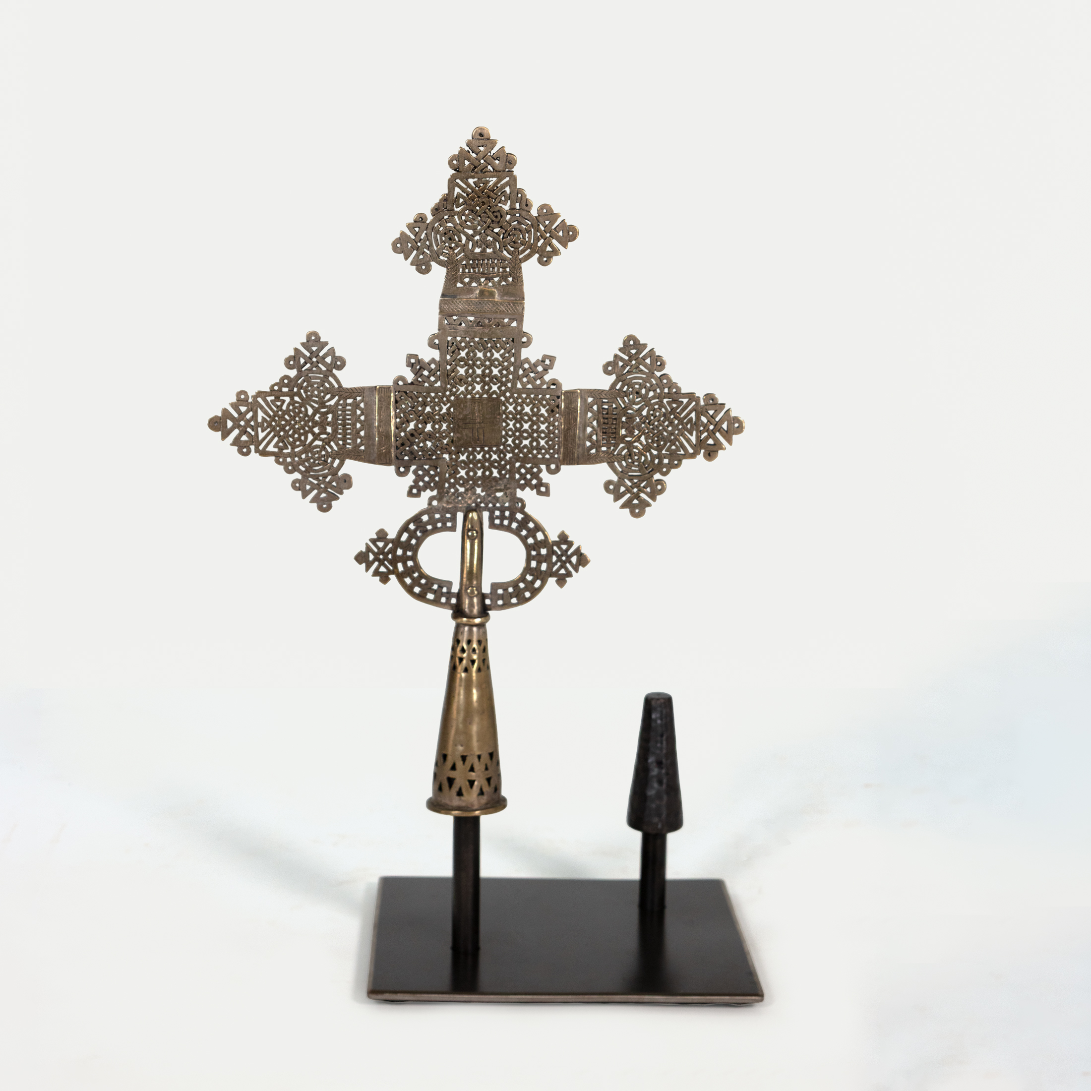 Smaller Ethiopian brass processional cross mounted on steel stand, obverse view