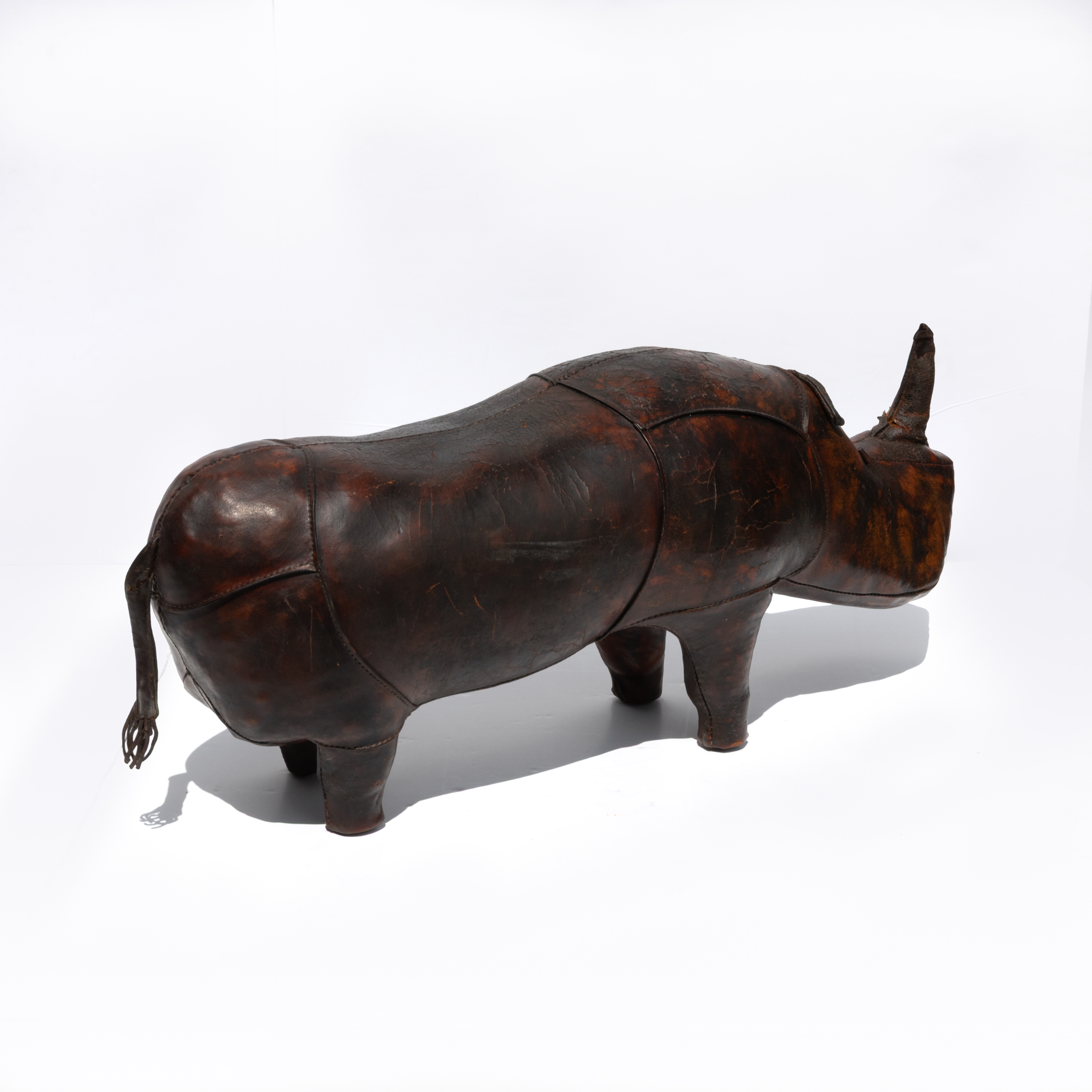 Dark brown leather rhinoceros footstool, photographed from an alternate angle.