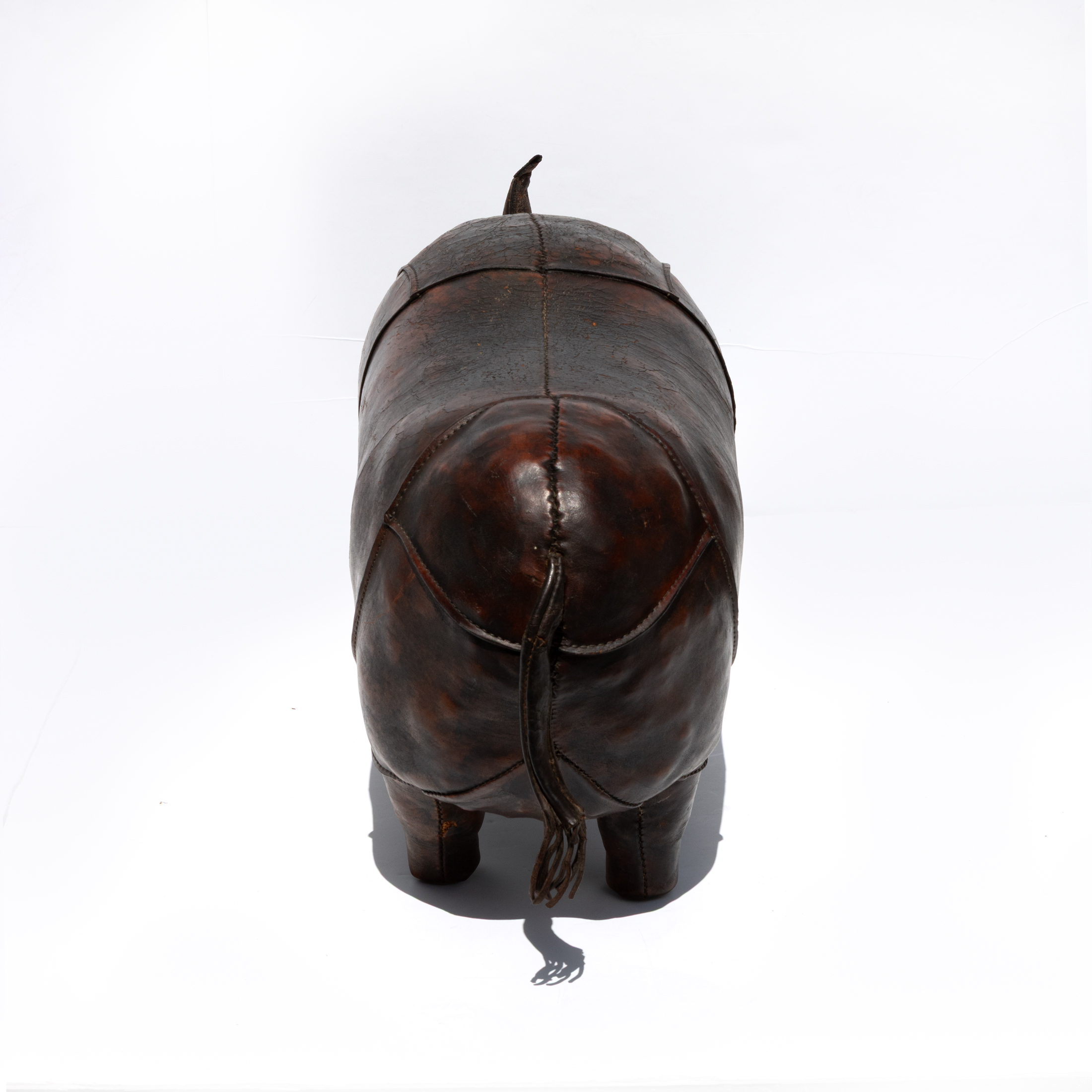 Dark brown leather rhinoceros footstool, photographed from an alternate angle.