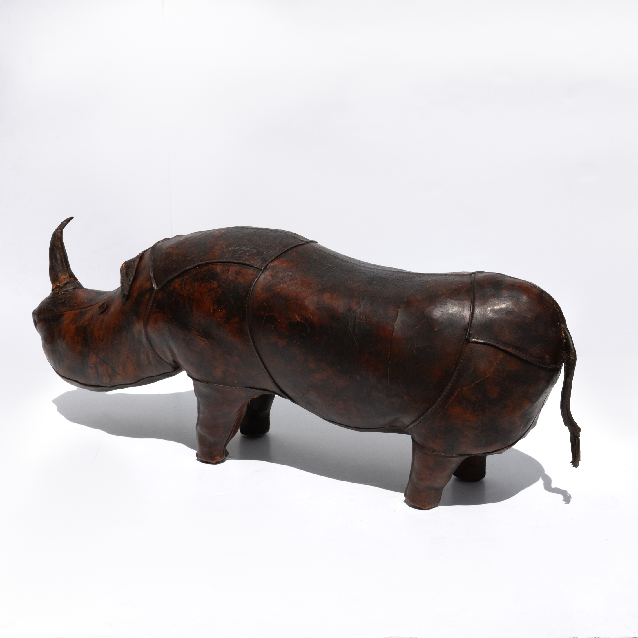 Dark brown leather rhinoceros footstool, photographed from an alternate angle.