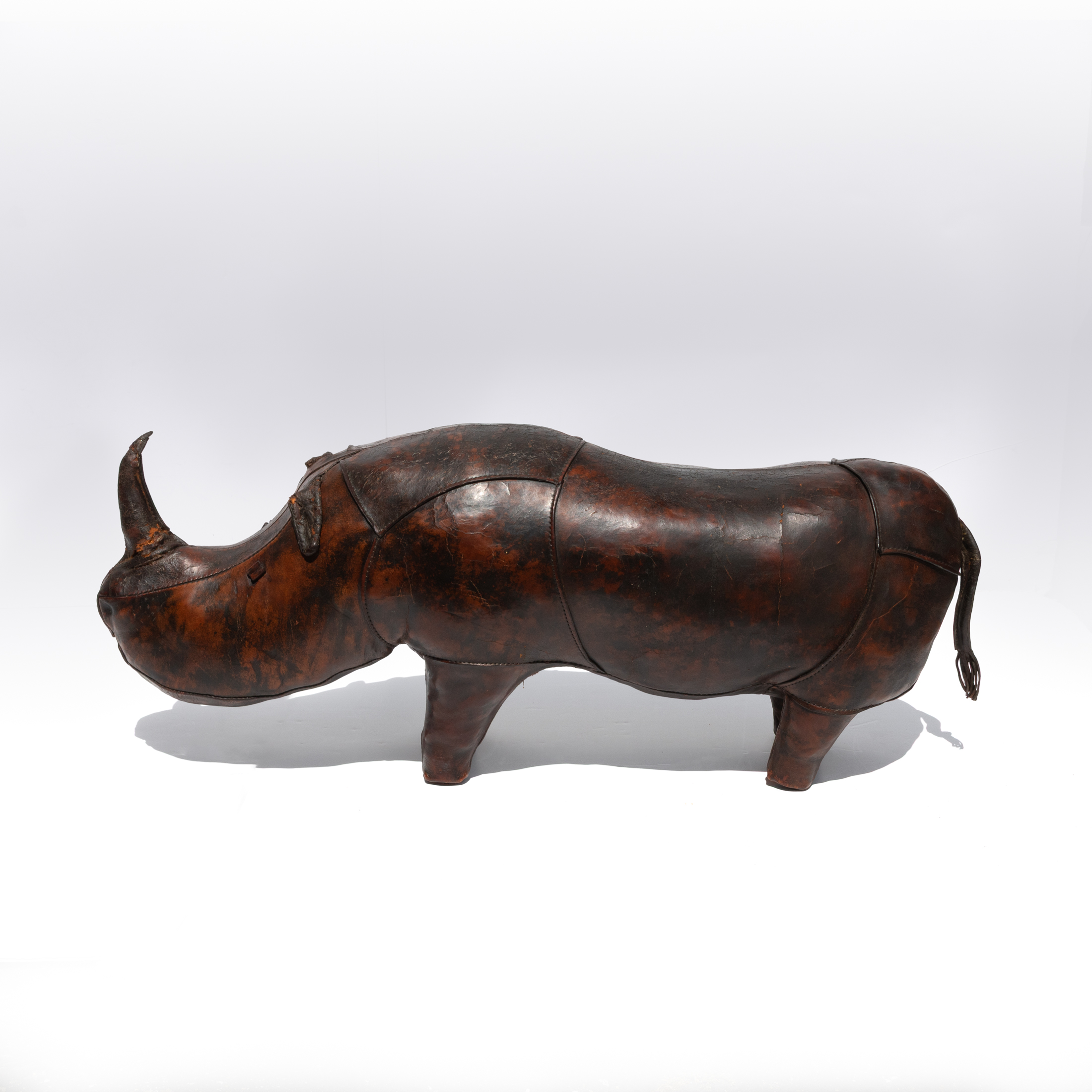 Dark brown leather rhinoceros footstool, photographed from an alternate angle.